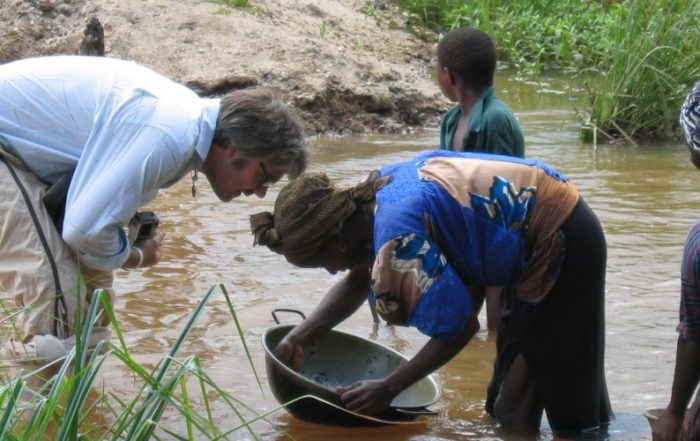 Woman gold panning in a diamond washing pit, Sierra Leone 2005.
